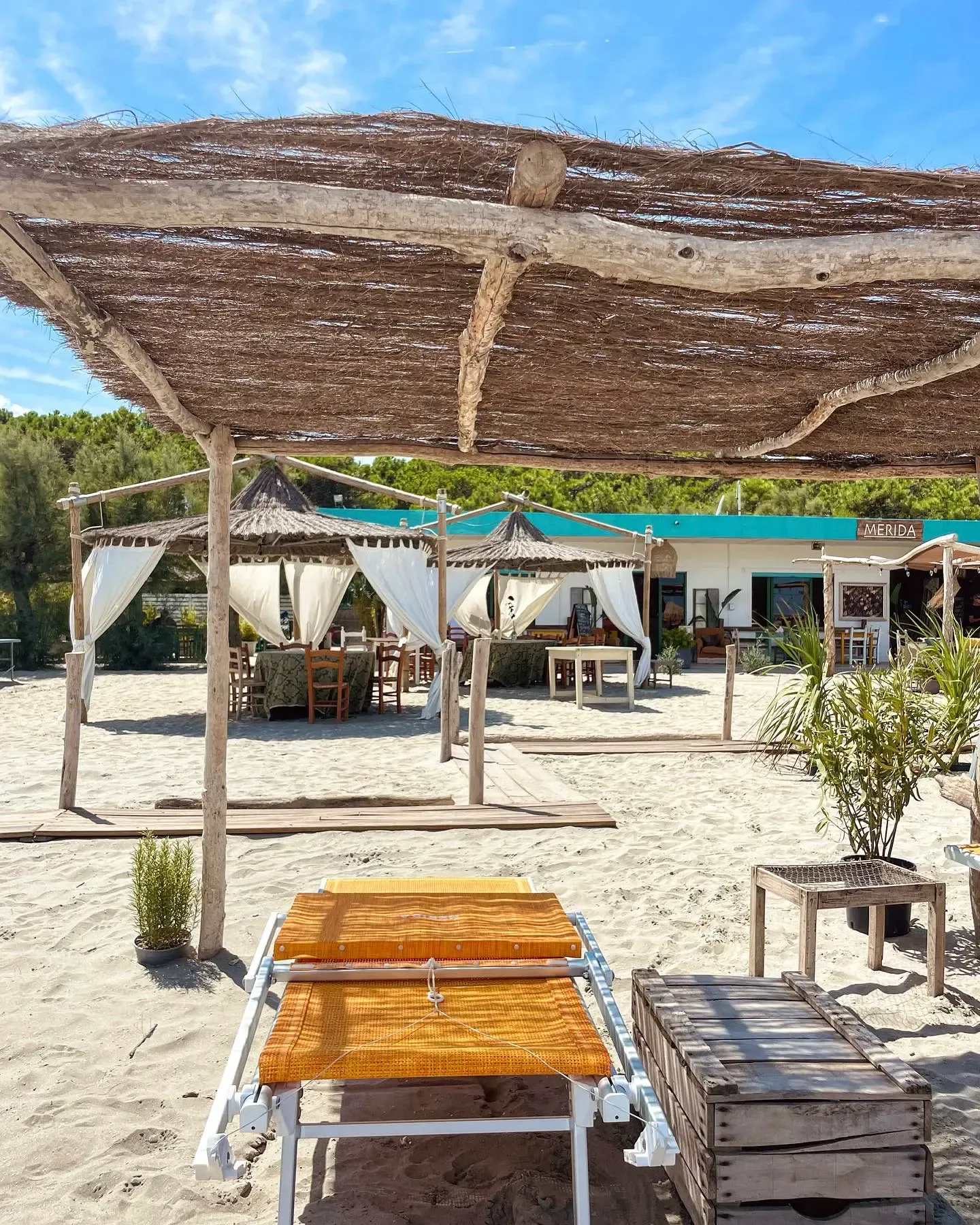 Panoramica della spiaggia di Casa Merida con pergole in legno, lettini e cabanas sulla sabbia