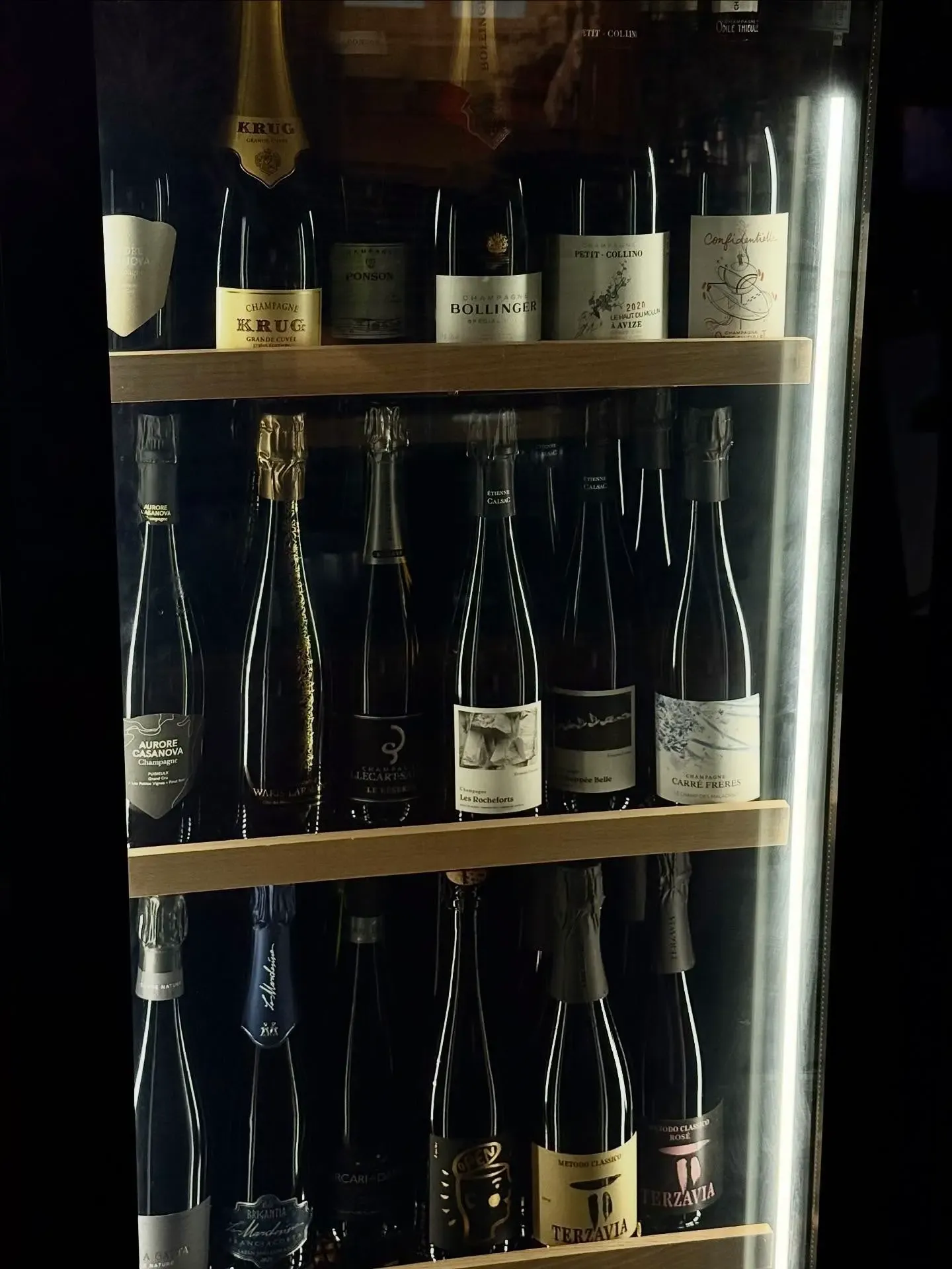 Celler di champagne con bottiglie di Krug, Bollinger e maison storiche in esposizione