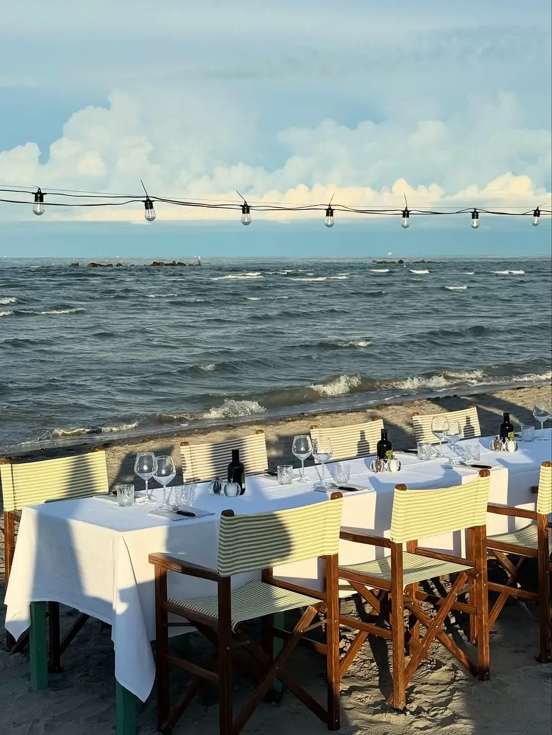 Tavolata apparecchiata sulla sabbia con vista sull'Adriatico